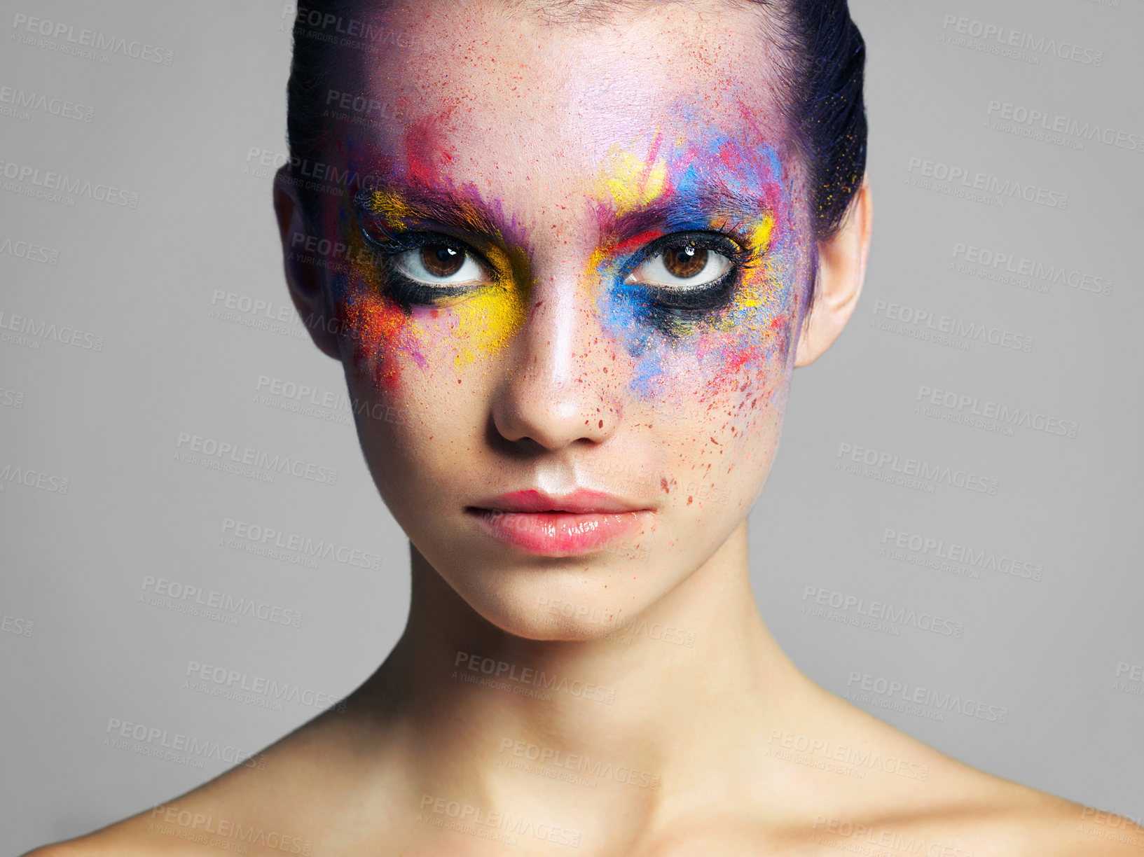 Buy stock photo Studio shot of an attractive young woman with brightly colored makeup against a gray background