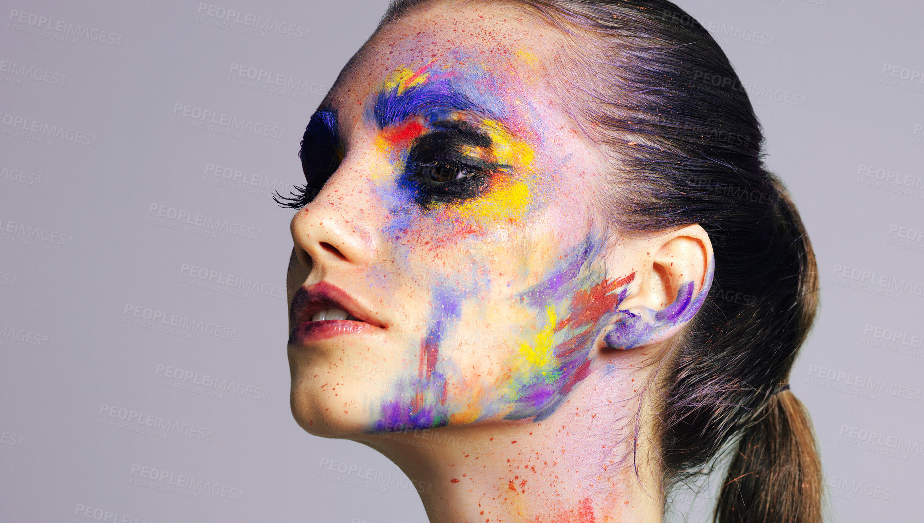 Buy stock photo Girl, beauty and makeup with paint in studio, creative art and unique cosmetics of aesthetic. Confident, woman and facial product with colour splash with rainbow, carnival culture and gray background