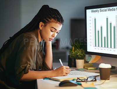 Buy stock photo Shot of a young businesswoman taking notes at the office