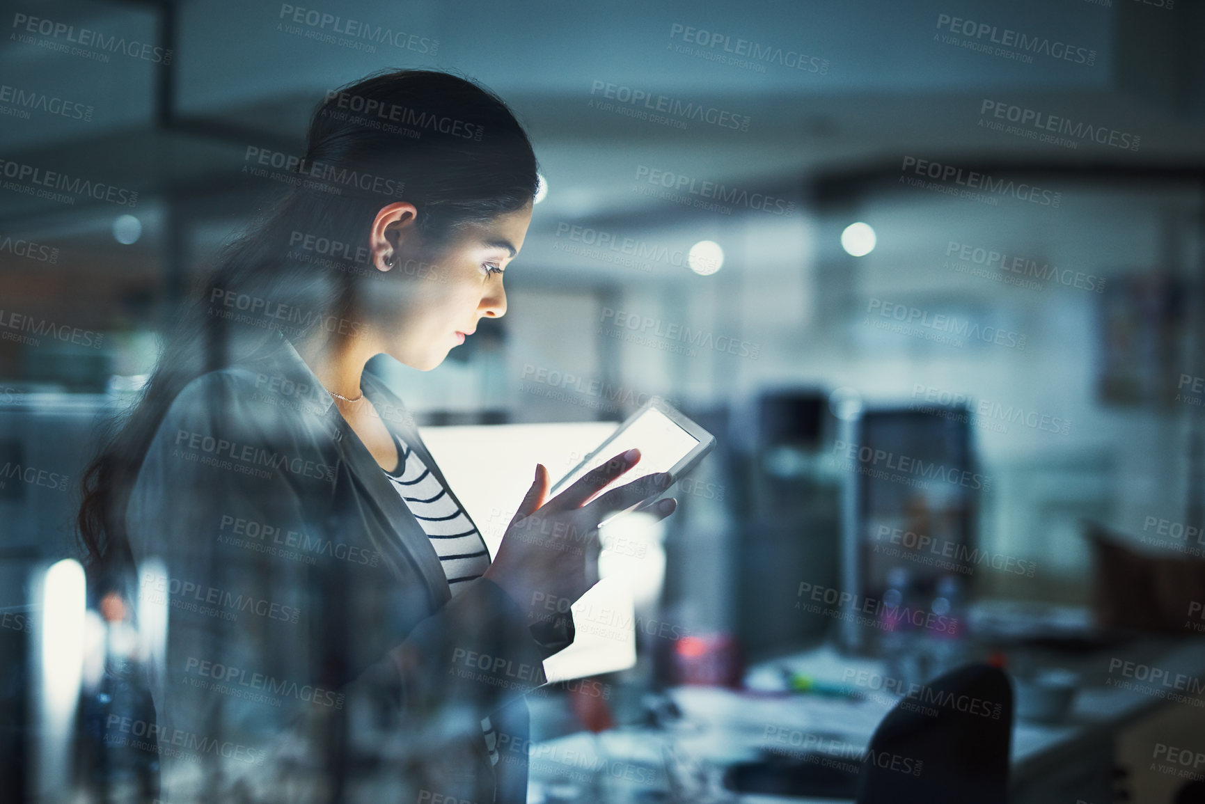 Buy stock photo Shot of a young businesswoman working late in the office