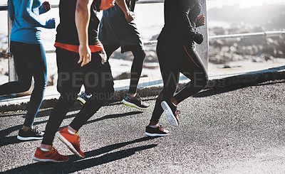 Buy stock photo Cropped shot of a group of unrecognizable people out for a run