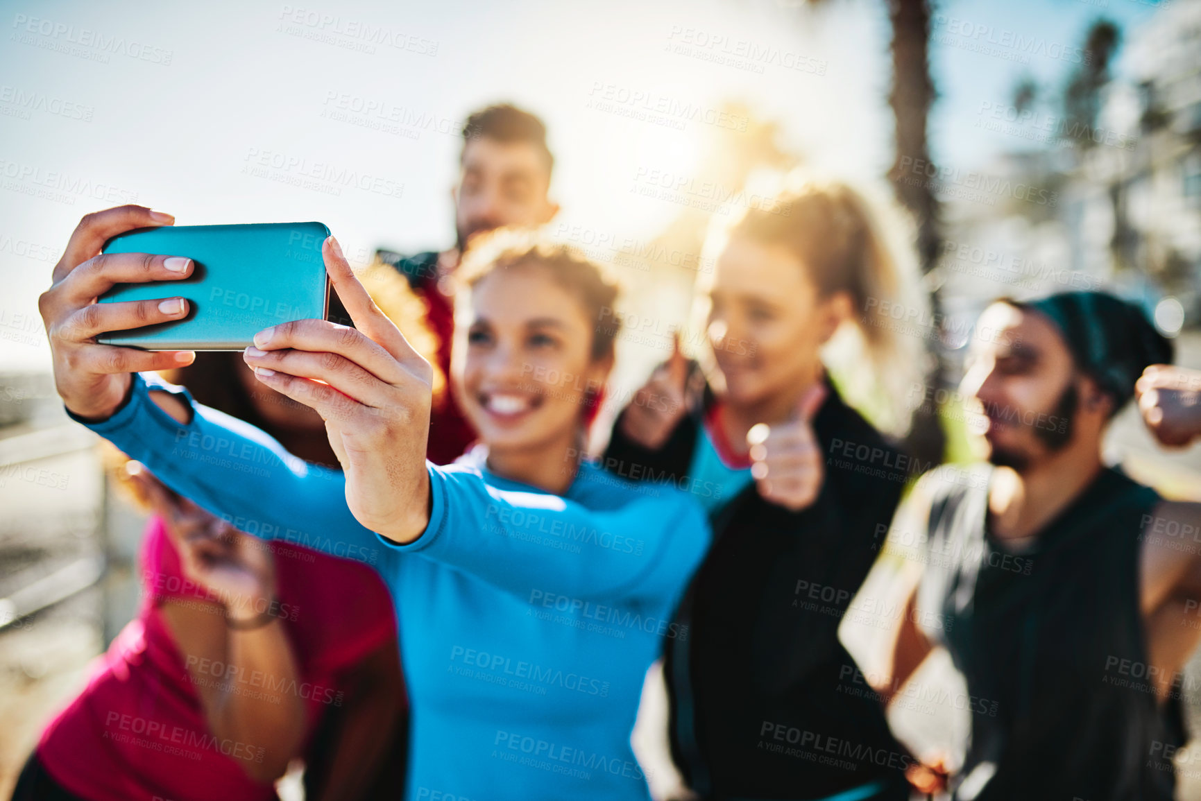 Buy stock photo Cropped shot of a fitness group taking a selfie while out for a run on the promenade