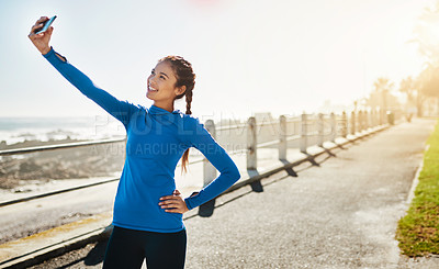 Buy stock photo Cropped shot of a woman taking a selfie while out for a run on the promenade