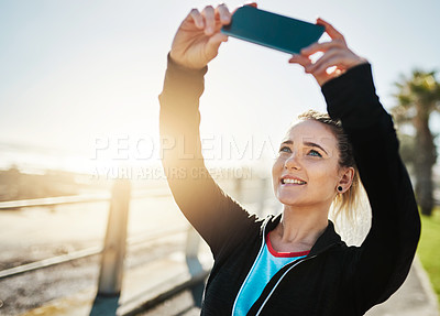 Buy stock photo Cropped shot of a woman taking a selfie while out for a run on the promenade