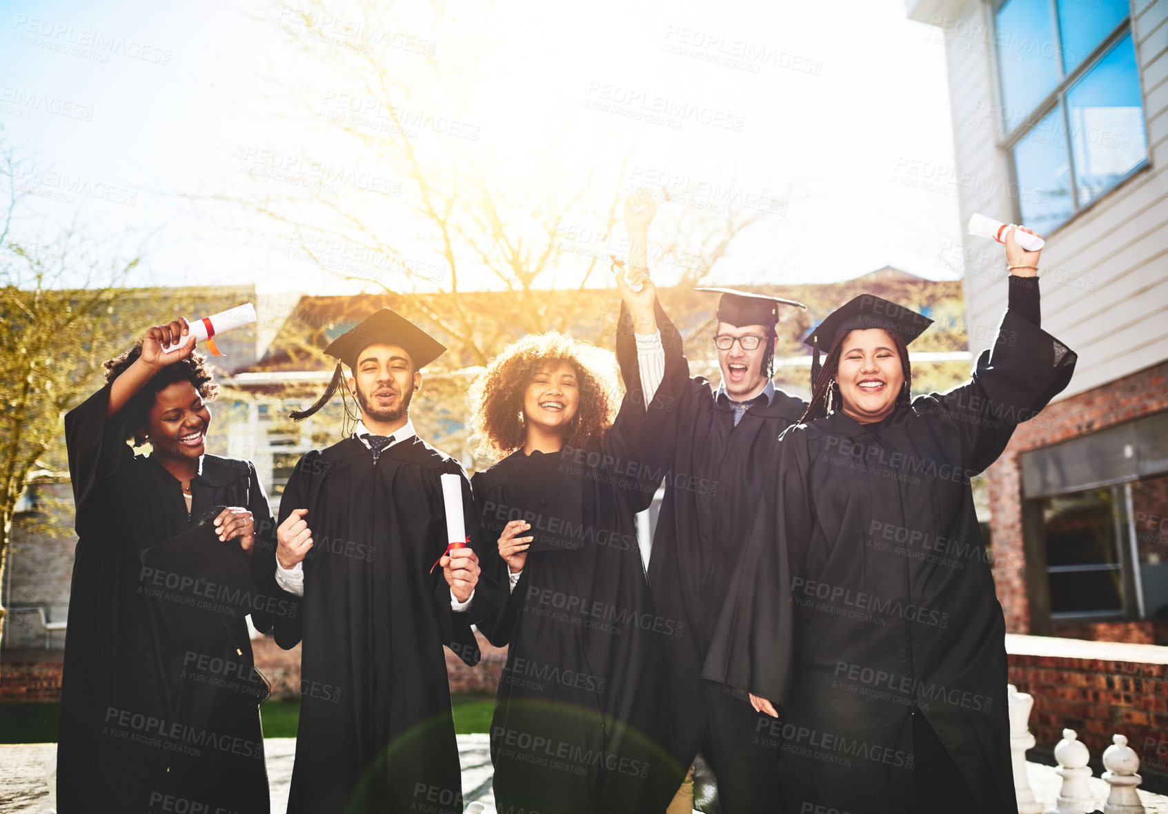 Buy stock photo Shot of a group of students standing together on graduation day