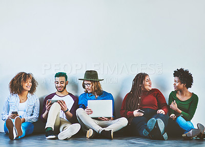 Buy stock photo Studio shot of a group of young people sitting on the floor and using wireless technology