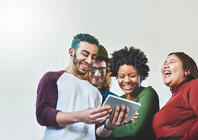 Buy stock photo Studio shot of a group of young people using a digital tablet together