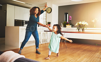 Buy stock photo Shot of a little girl and her mother dancing at home