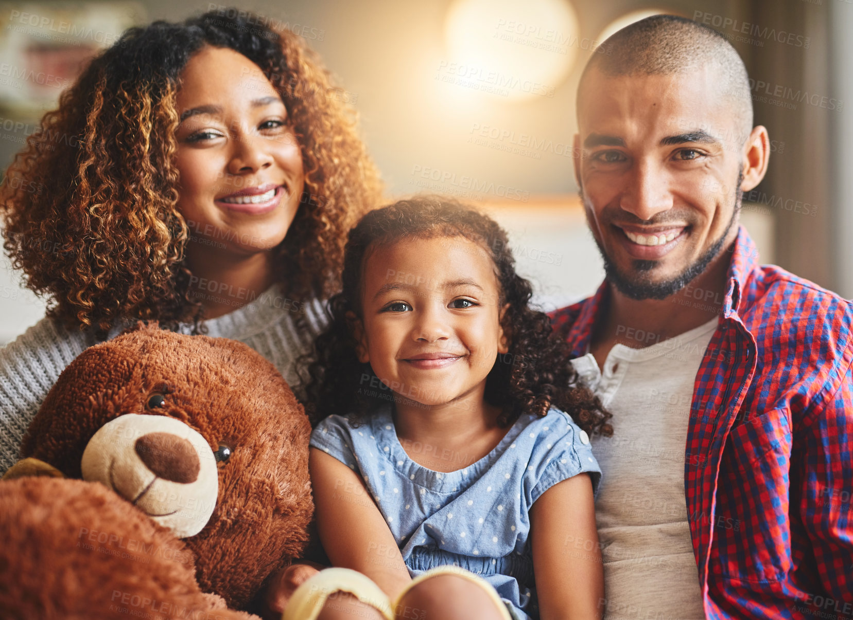 Buy stock photo Portrait of a happy young family of three spending quality time together at home