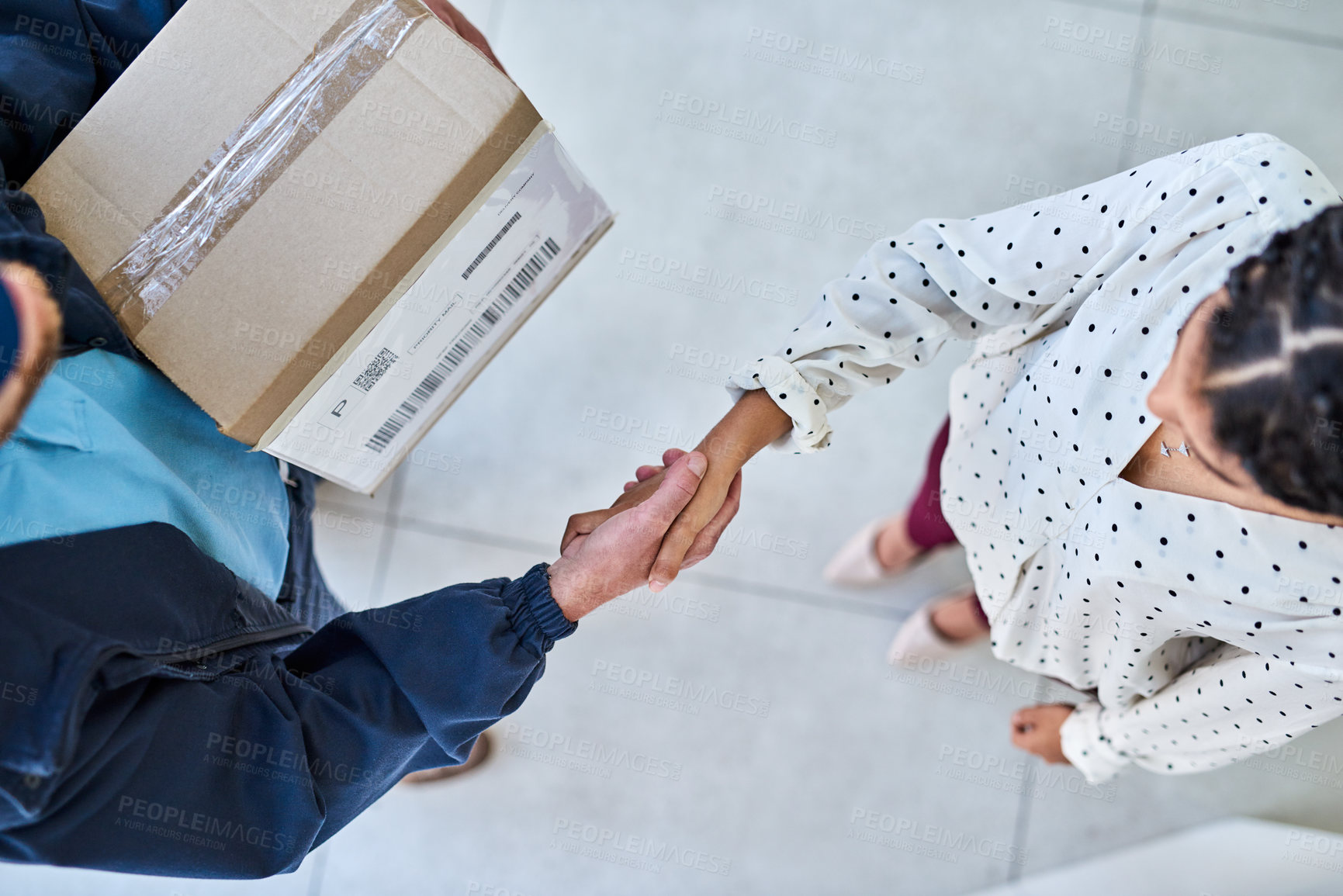 Buy stock photo High angle shot of an unrecognizable delivery man shaking hands with a female customer