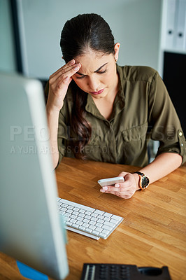 Buy stock photo Shot of a young businesswoman looking stressed out while using a cellphone in an office