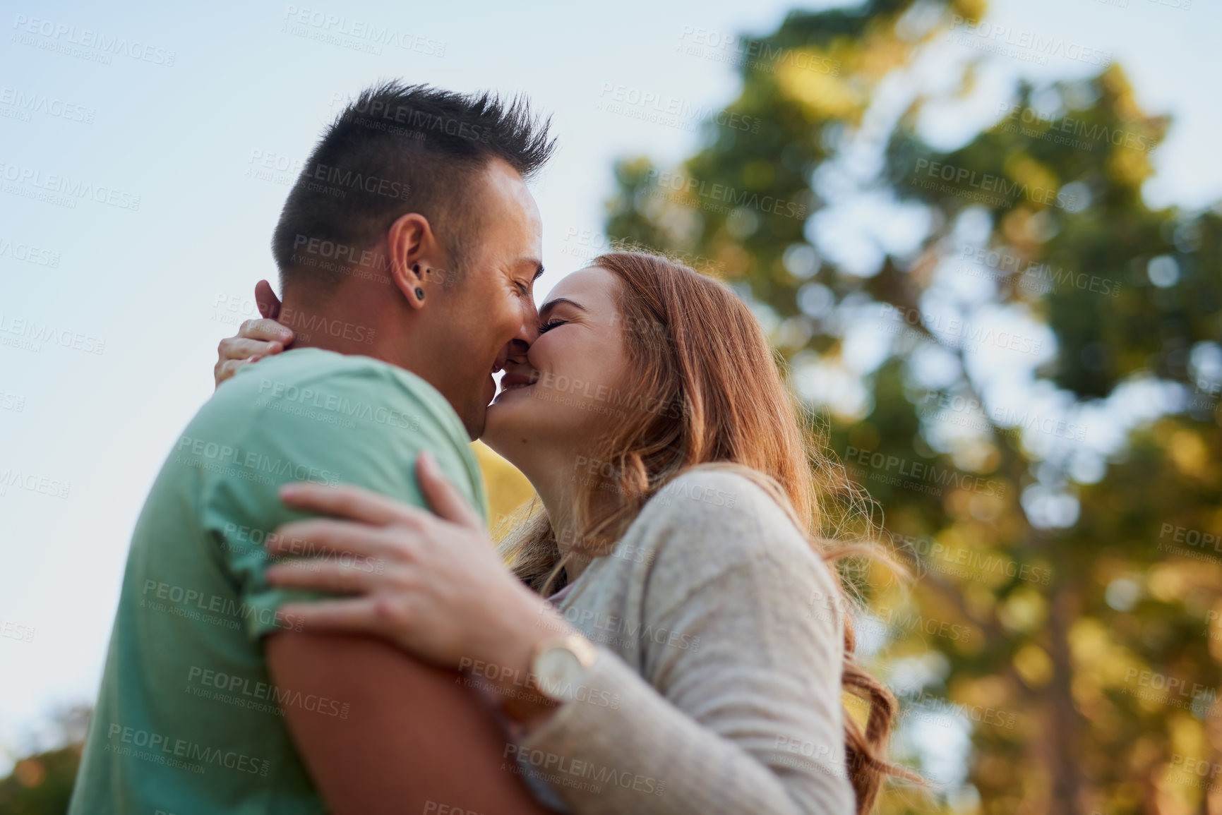 Buy stock photo Outdoor, couple and love with kiss for relationship, connection and bonding together on date. Happy people, woman and man with hug for admiration, affection and commitment with security in Canada