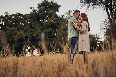 Buy stock photo Shot of an affectionate young couple in the countryside