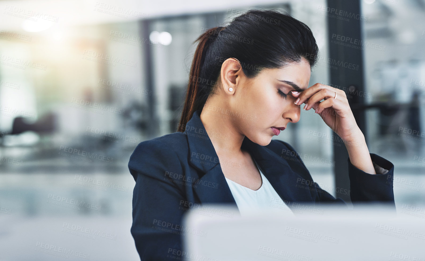 Buy stock photo Cropped shot of an attractive young businesswoman experiencing a headache in her office