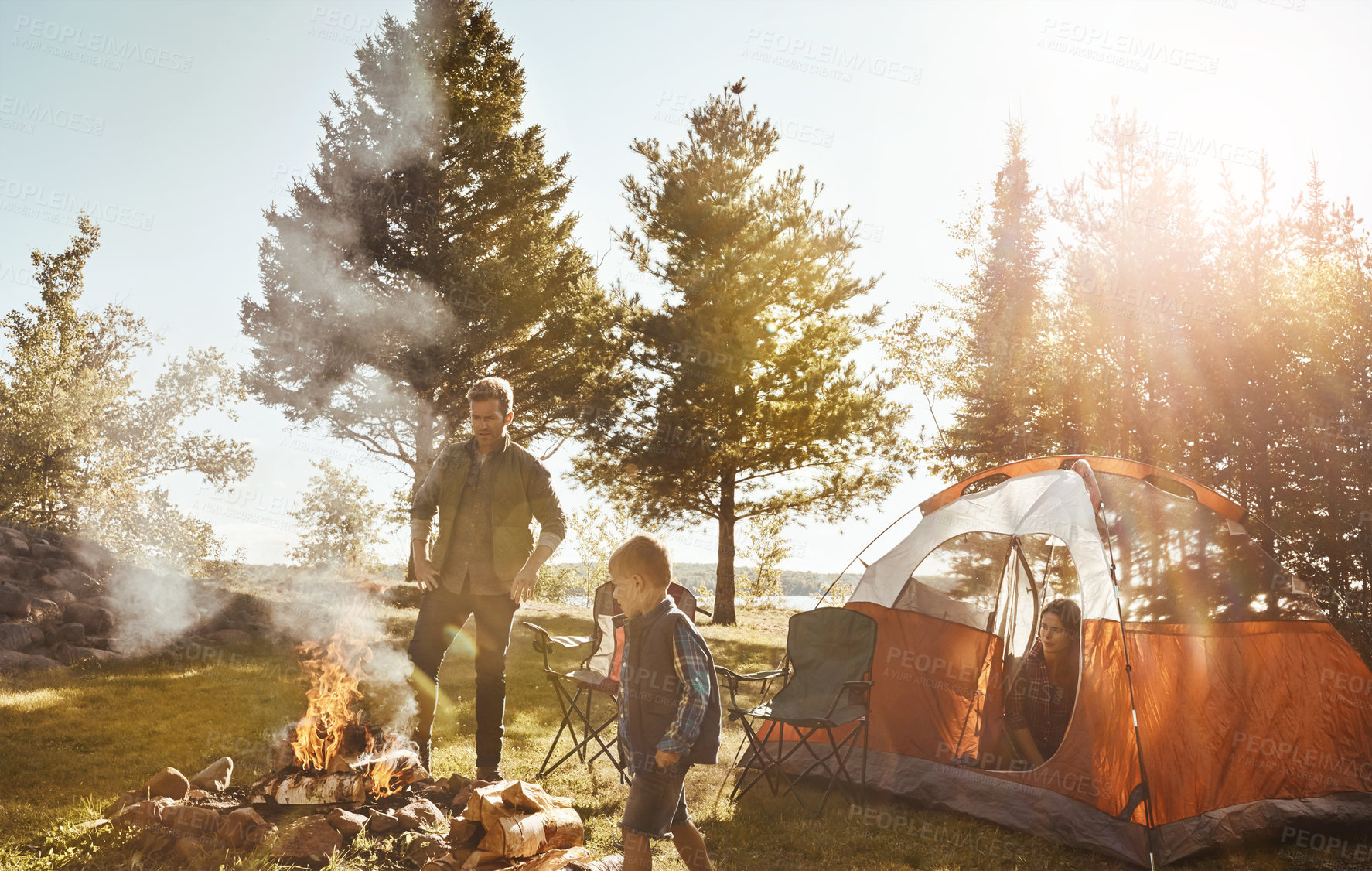 Buy stock photo Shot of a young family camping in the forest