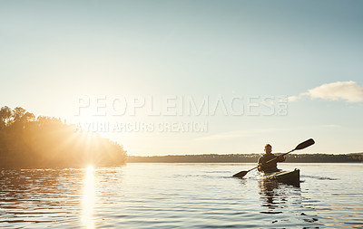 Buy stock photo Shot of a young man kayaking on a lake outdoors
