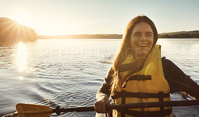Buy stock photo Shot of a beautiful young woman kayaking on a lake outdoors