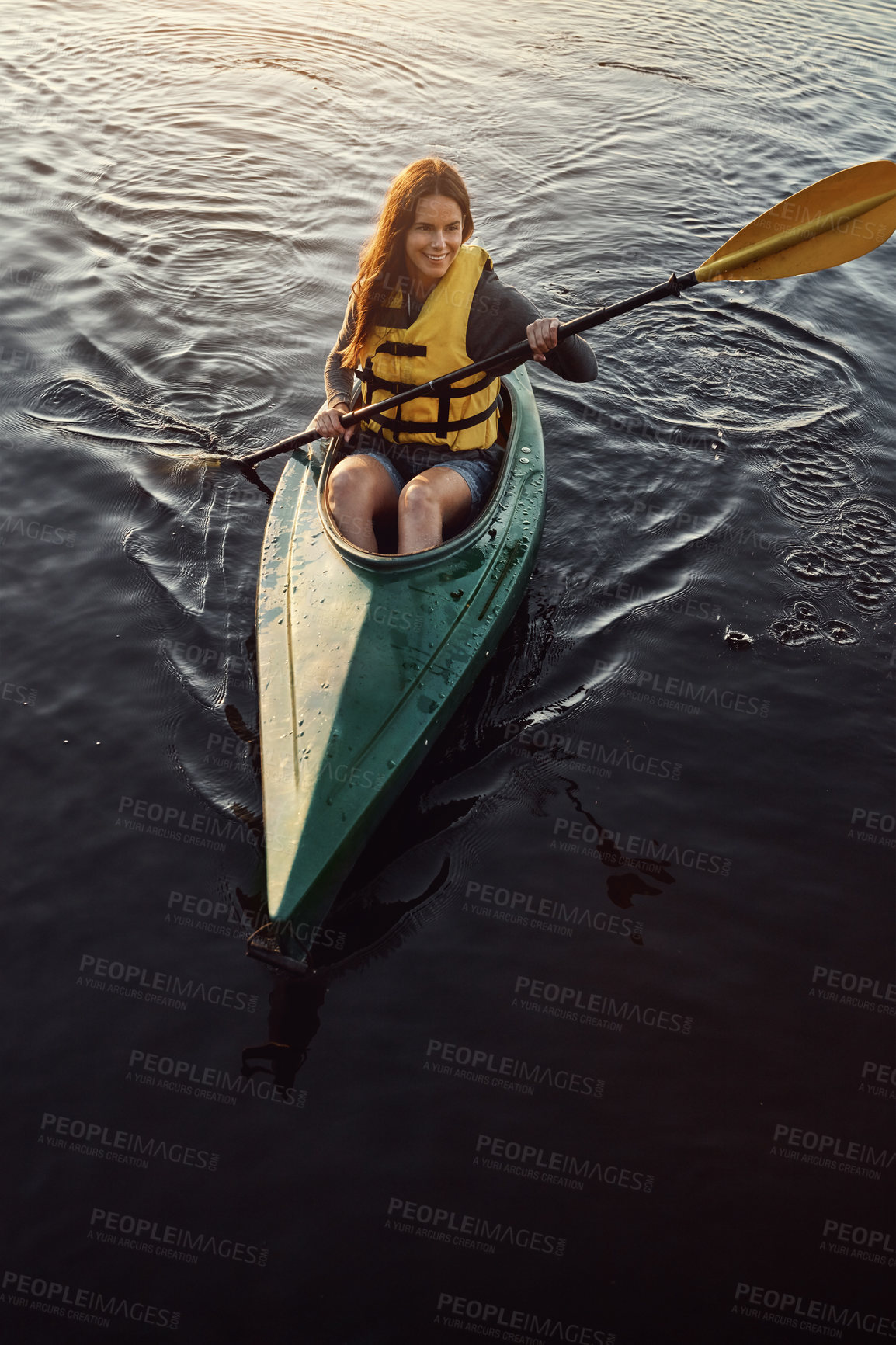 Buy stock photo High angle shot of a beautiful young woman kayaking on a lake outdoors