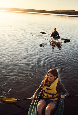 Buy stock photo High angle shot of a young couple kayaking on a lake outdoors