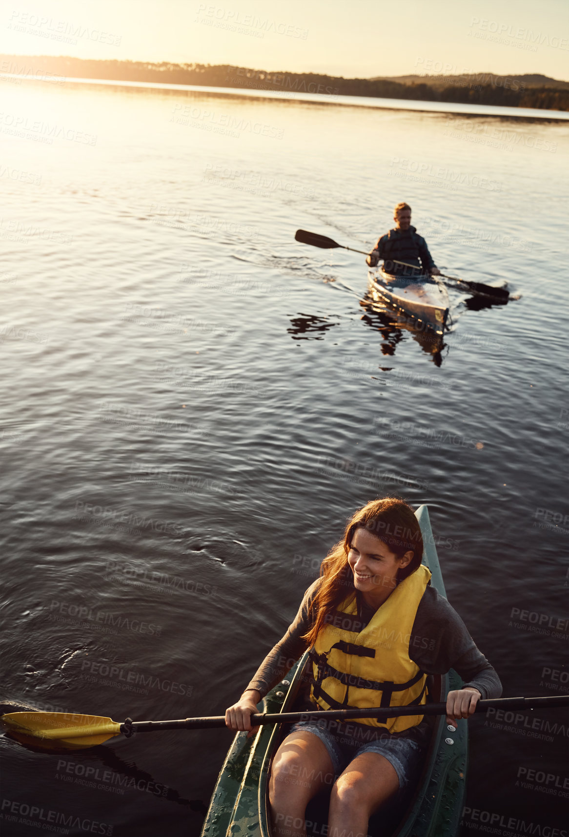 Buy stock photo High angle shot of a young couple kayaking on a lake outdoors