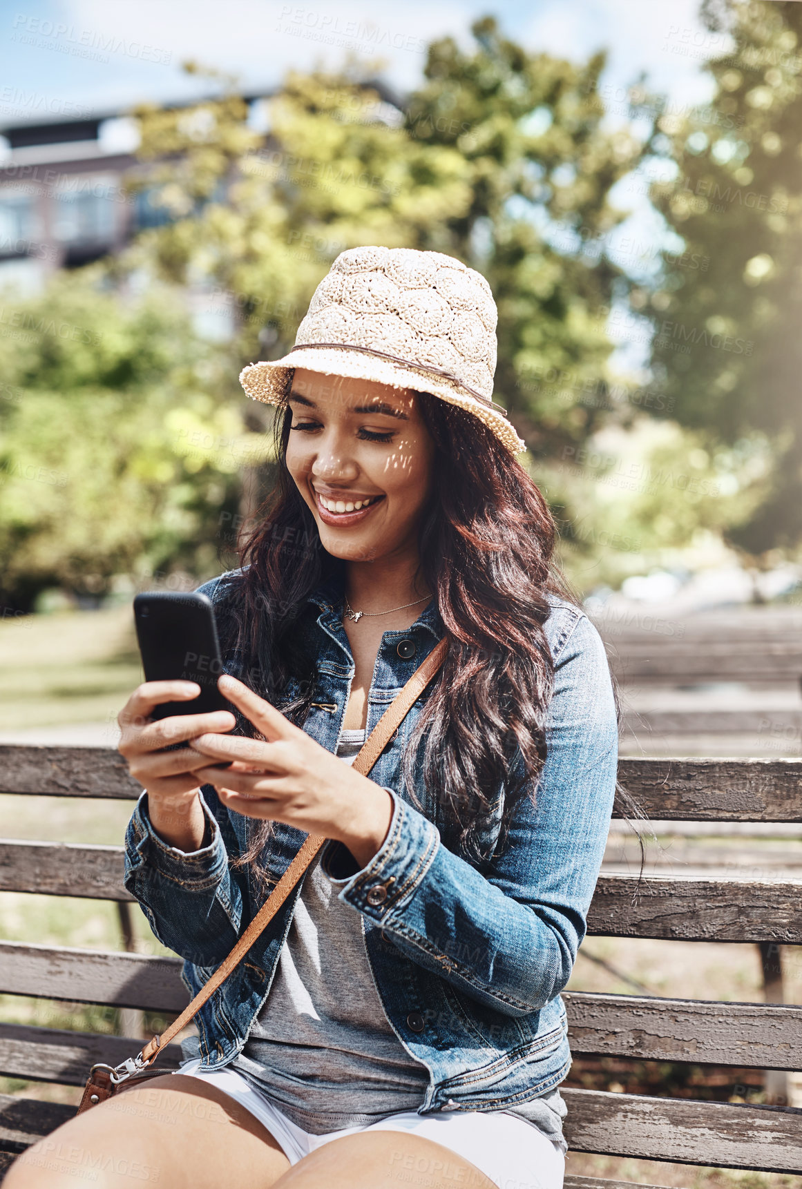 Buy stock photo Shot of an attractive young woman using a cellphone at the park