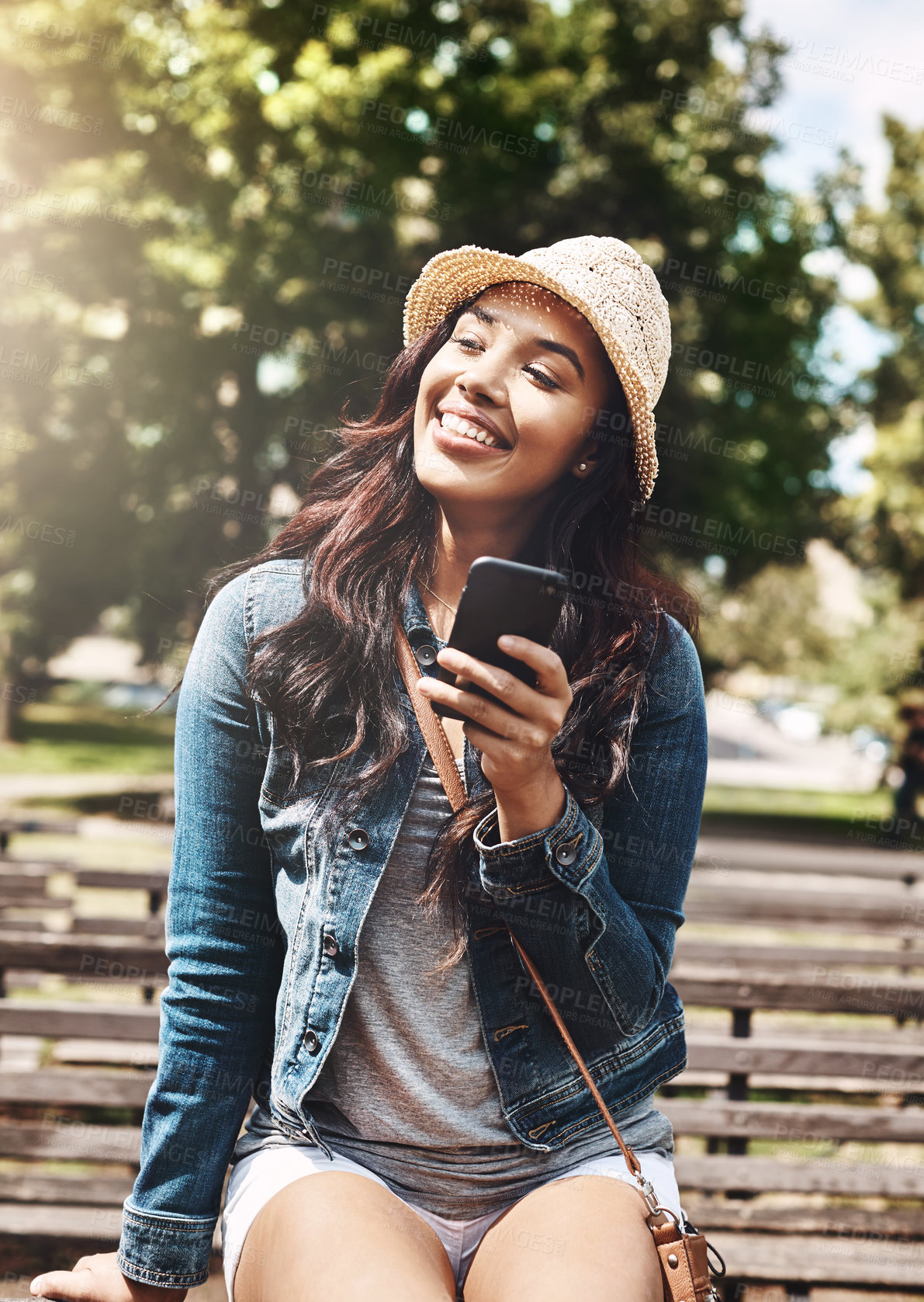 Buy stock photo Shot of an attractive young woman using a cellphone at the park