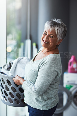 Buy stock photo Portrait of a mature woman doing laundry at home