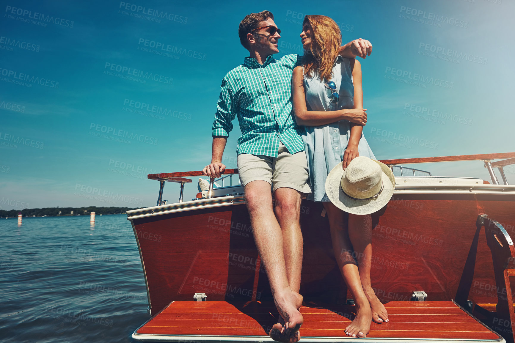 Buy stock photo Shot of a young couple spending time together on a yacht