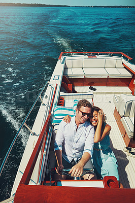 Buy stock photo High angle shot of an affectionate young couple sailing on the open seas in their yacht