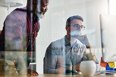 Buy stock photo Shot of two businesspeople working on a computer in an office