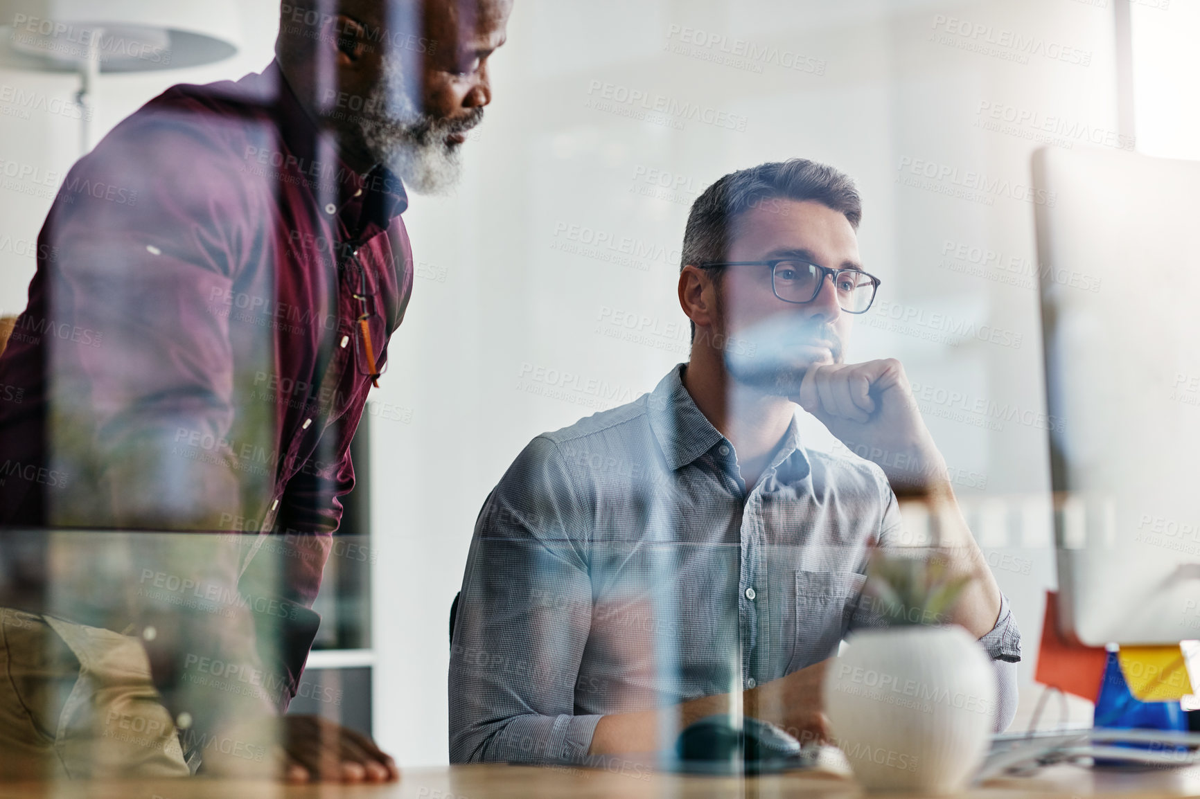 Buy stock photo Shot of two businesspeople working on a computer in an office