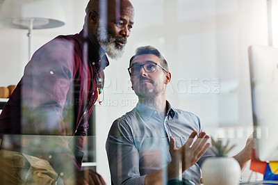 Buy stock photo Shot of two businesspeople working on a computer in an office