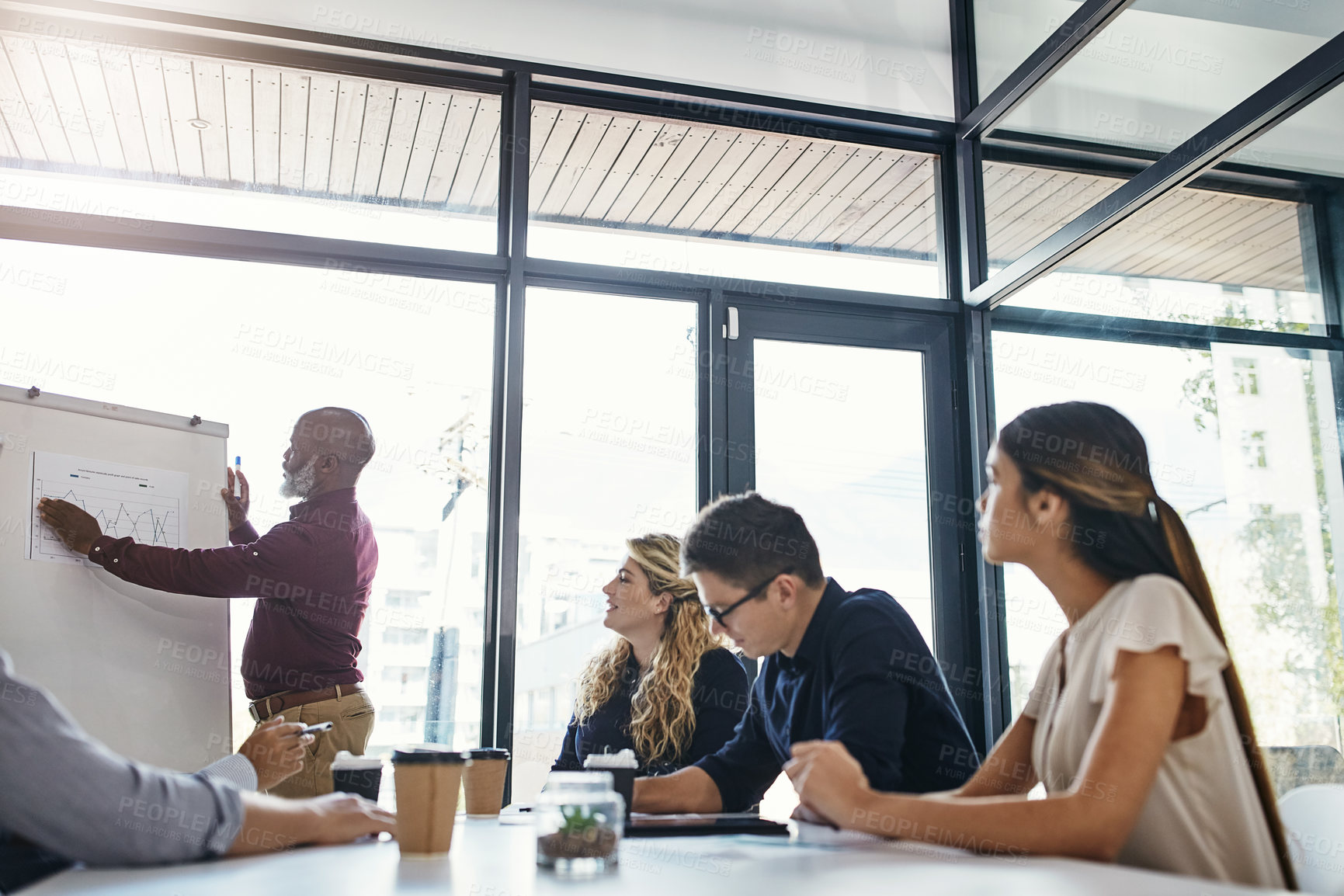 Buy stock photo Shot of a mature businessman giving a presentation to his colleagues in an office