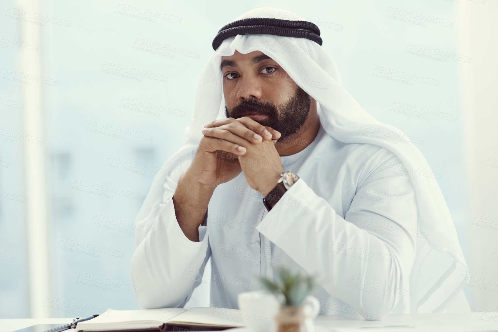 Buy stock photo Cropped portrait of a young businessman dressed in Islamic traditional clothing working in his office