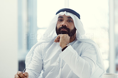 Buy stock photo Cropped portrait of a young businessman dressed in Islamic traditional clothing working in his office