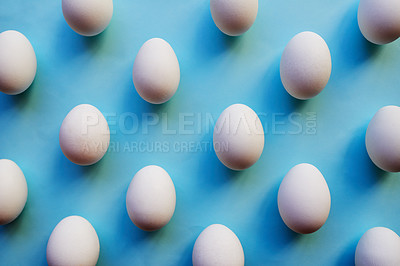 Buy stock photo Studio shot of a bunch of eggs against a colored background neatly placed in rows