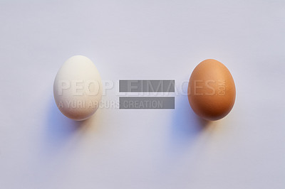 Buy stock photo Studio shot of two different types of eggs placed next to each other with a equal sign in the middle