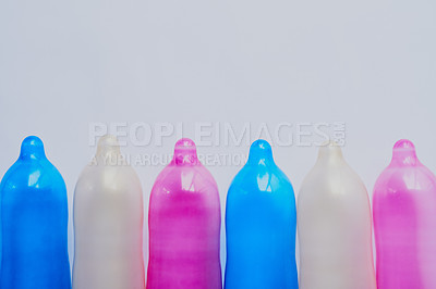 Buy stock photo Colorful, condoms or open in studio for education, sexual health or STD awareness. Contraception, latex or transgender pride on gray background for creativity, HIV prevention or rubber for protection