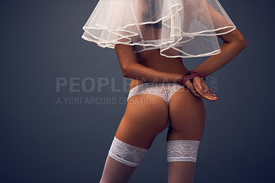 Buy stock photo Rearview studio shot of an unrecognizable woman posing with her hands tied behind her back against a blue background