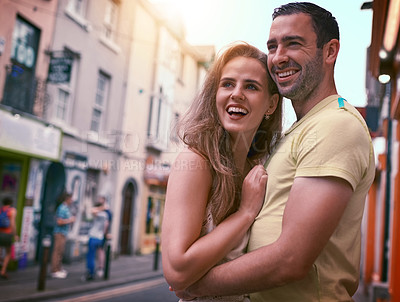 Buy stock photo Shot of a happy young couple sharing an affectionate moment while exploring a foreign city