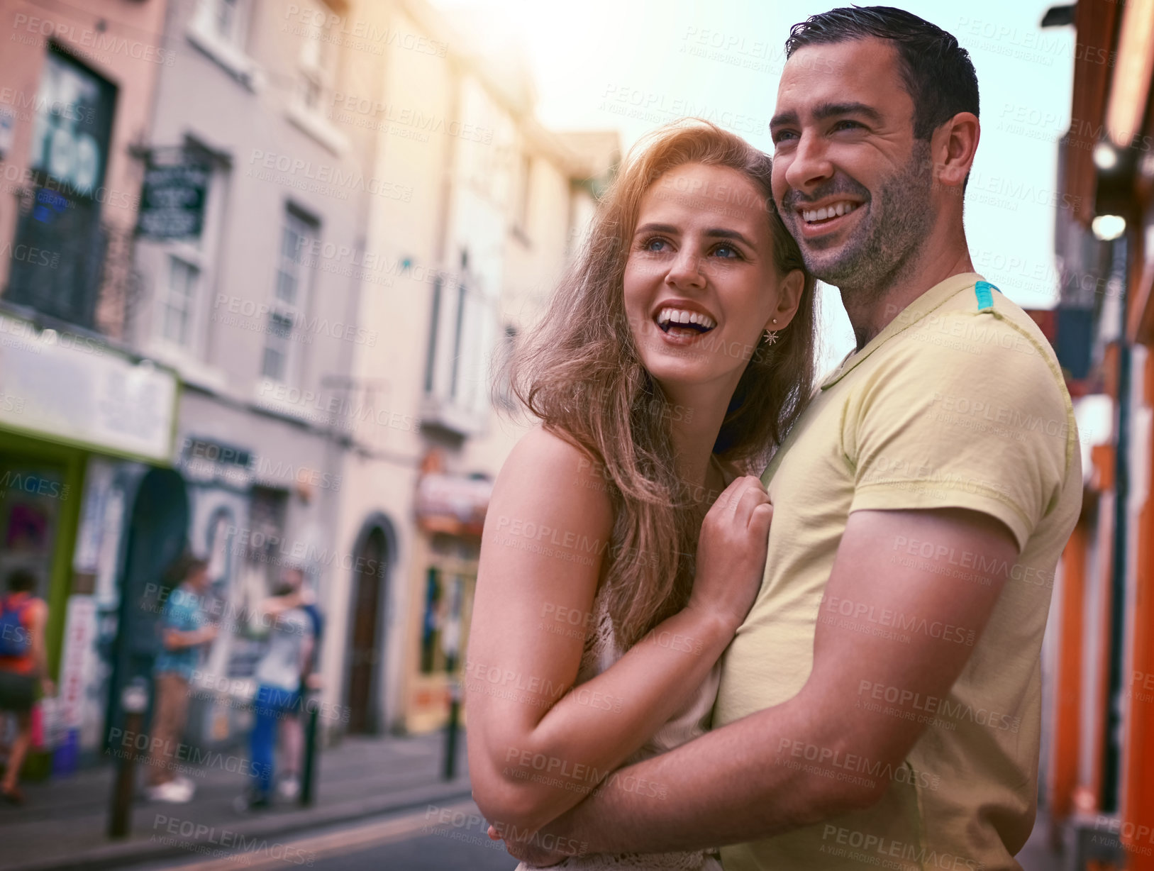 Buy stock photo Shot of a happy young couple sharing an affectionate moment while exploring a foreign city