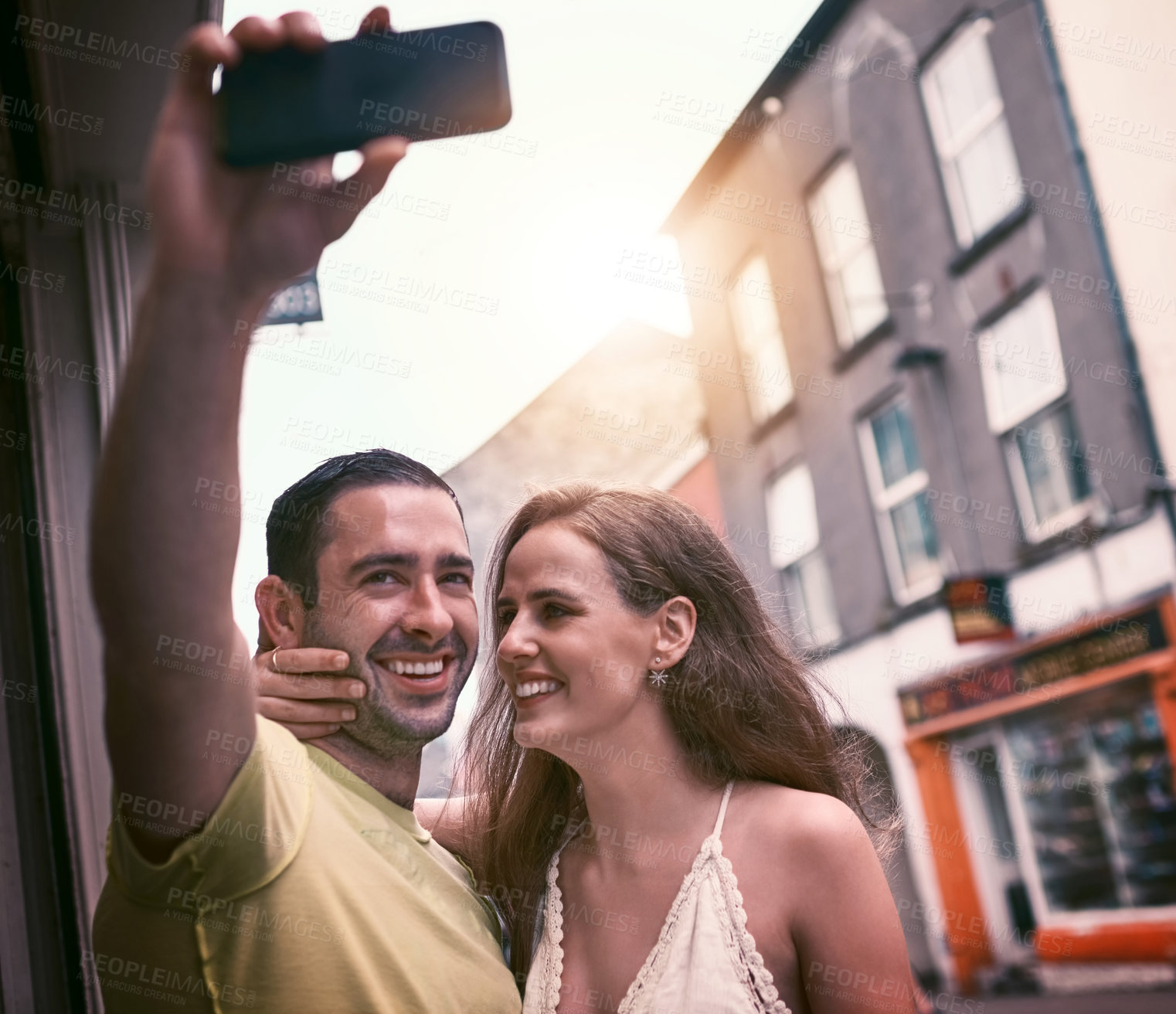 Buy stock photo Shot of a happy young couple taking selfies while exploring a foreign city