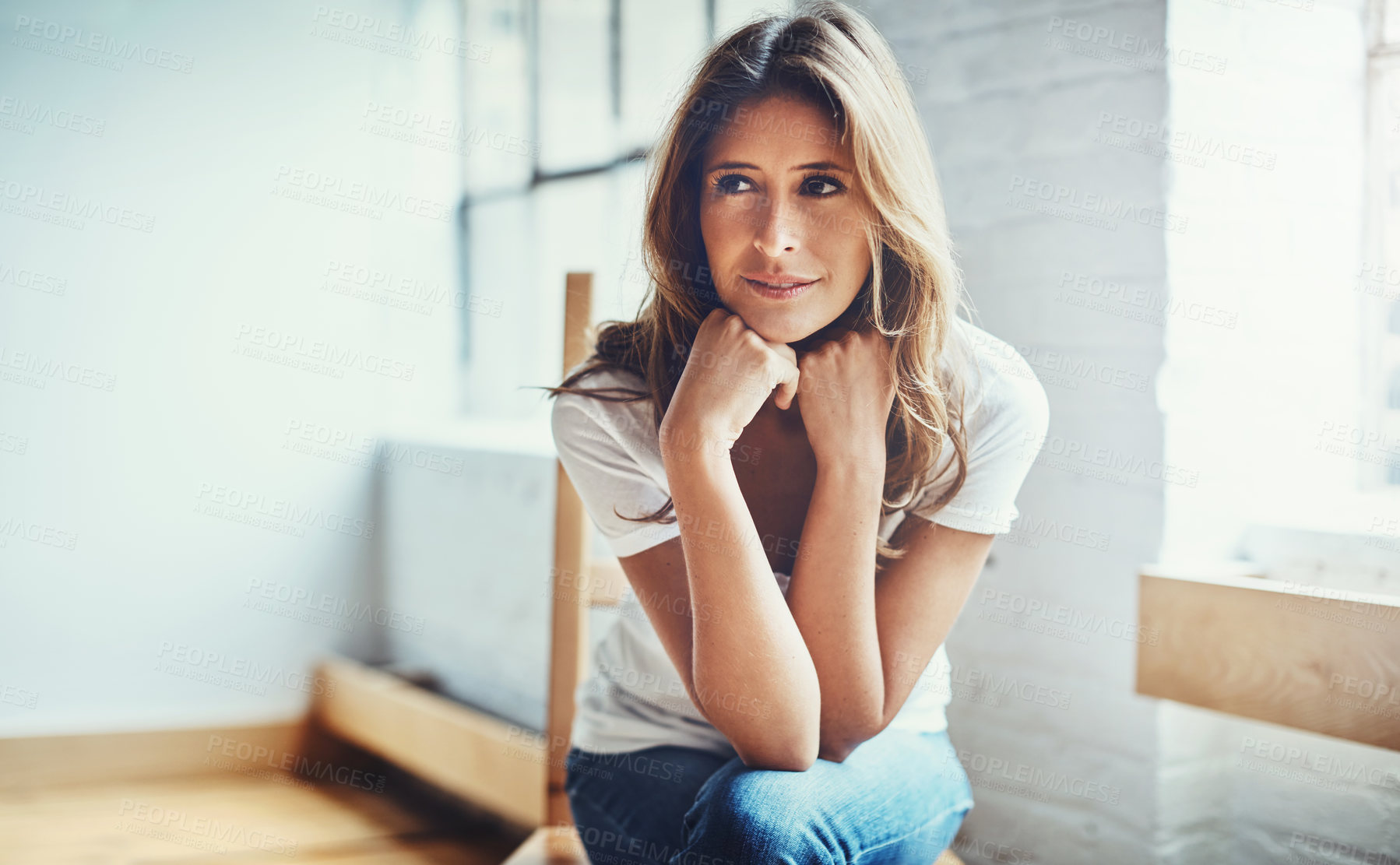 Buy stock photo Shot of an attractive and thoughtful young woman relaxing at home