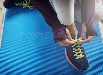 Buy stock photo High angle shot of an unidentifiable woman tying her shoelaces before a workout