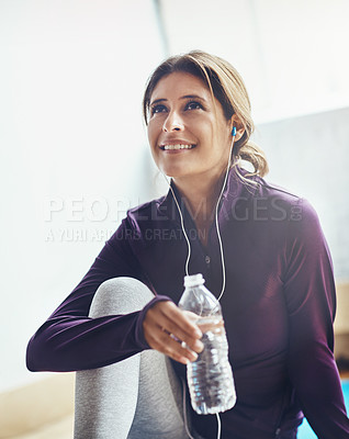 Buy stock photo Shot of an attractive young woman drinking water while working out at home