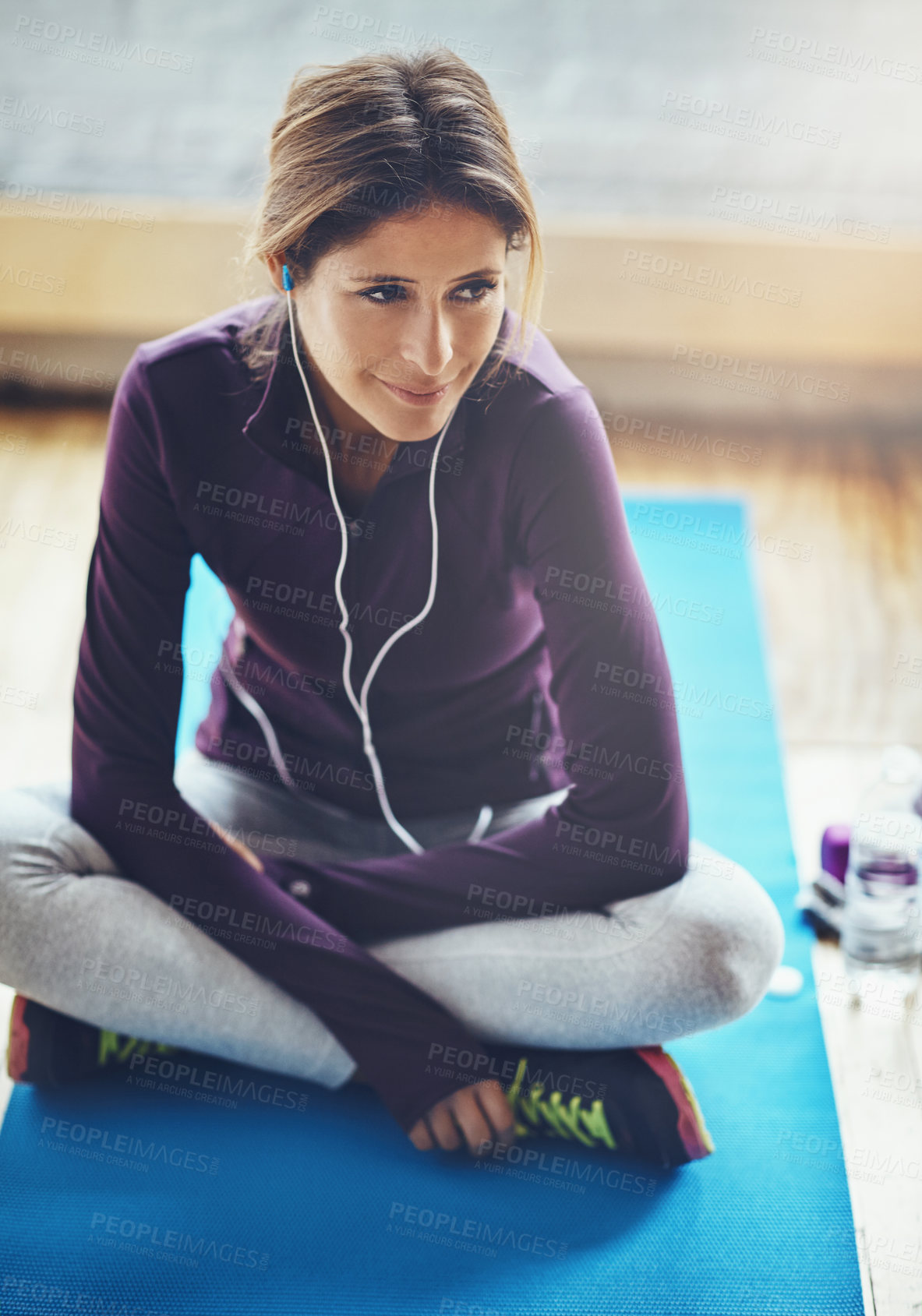 Buy stock photo Shot of an attractive young woman listening to music while working out at home