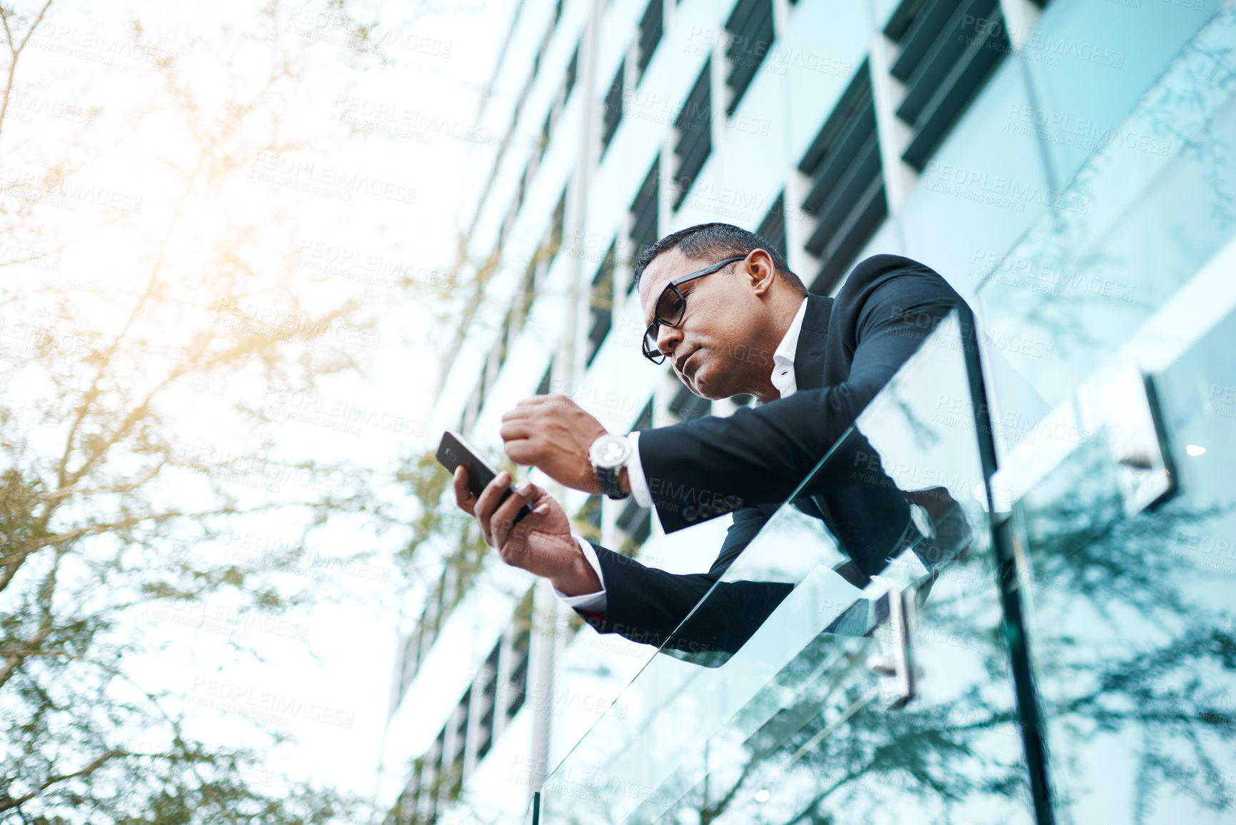 Buy stock photo Portrait, executive and phone, outdoor and balcony of company, corporate and mature person. Businessman, employee and serious for deal or project, mobile and communication, suit and texting for job