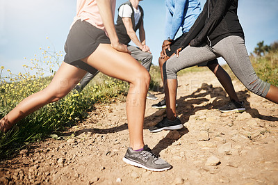 Buy stock photo Cropped shot of a fitness group stretching before their run