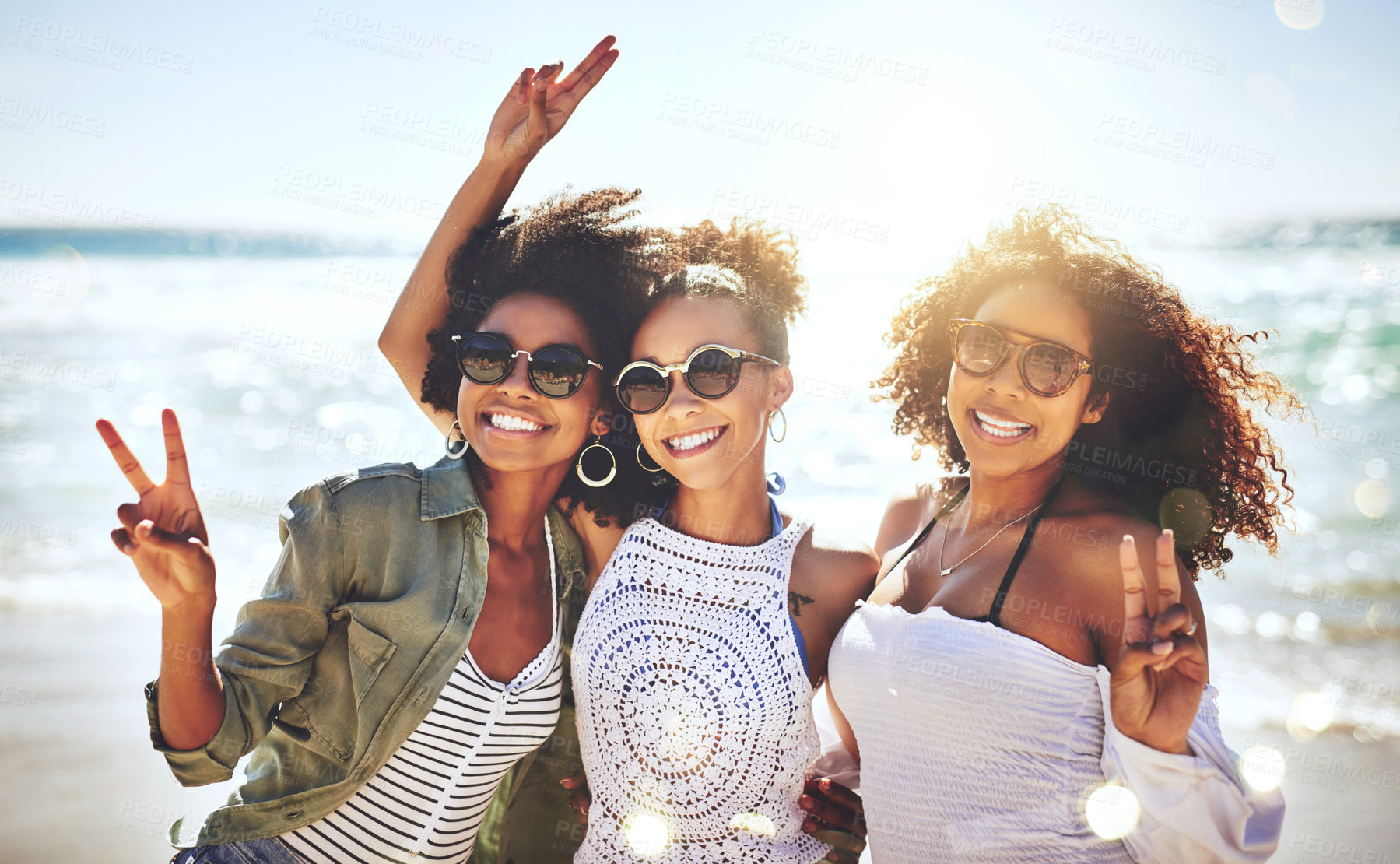 Buy stock photo Cropped shot of three friends enjoying themselves at the beach on a sunny day