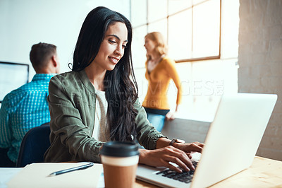 Buy stock photo Cropped shot of an attractive young businesswoman working in a modern office with her colleagues in the background